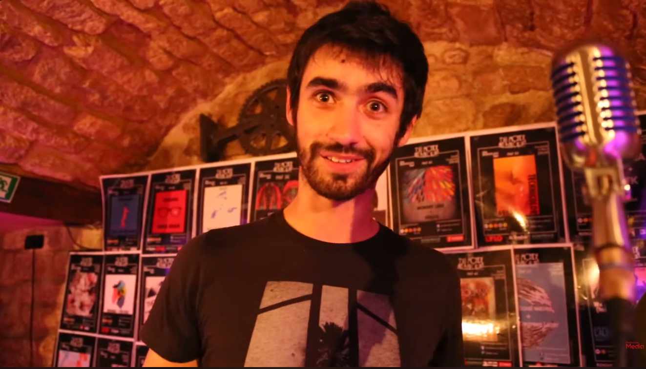Portrait d’un intervenant enregistré au micro lors d’un entretien vidéo.